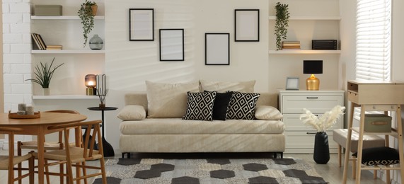 Photo of Comfortable sofa, table, chairs and dresser indoors. Interior design