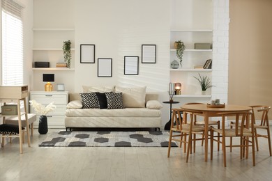 Photo of Comfortable sofa, table, chairs and dresser indoors. Interior design