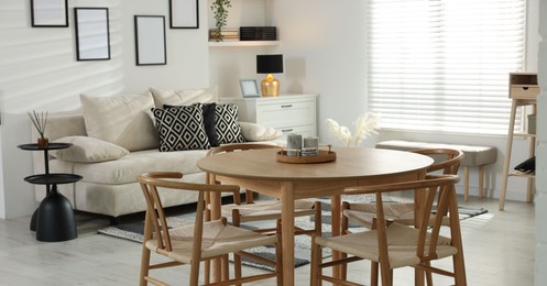 Photo of Table, chairs and comfortable sofa indoors. Interior design