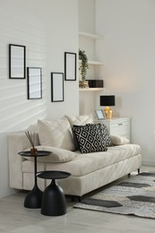 Photo of Comfortable sofa, dresser and different decor indoors. Interior design