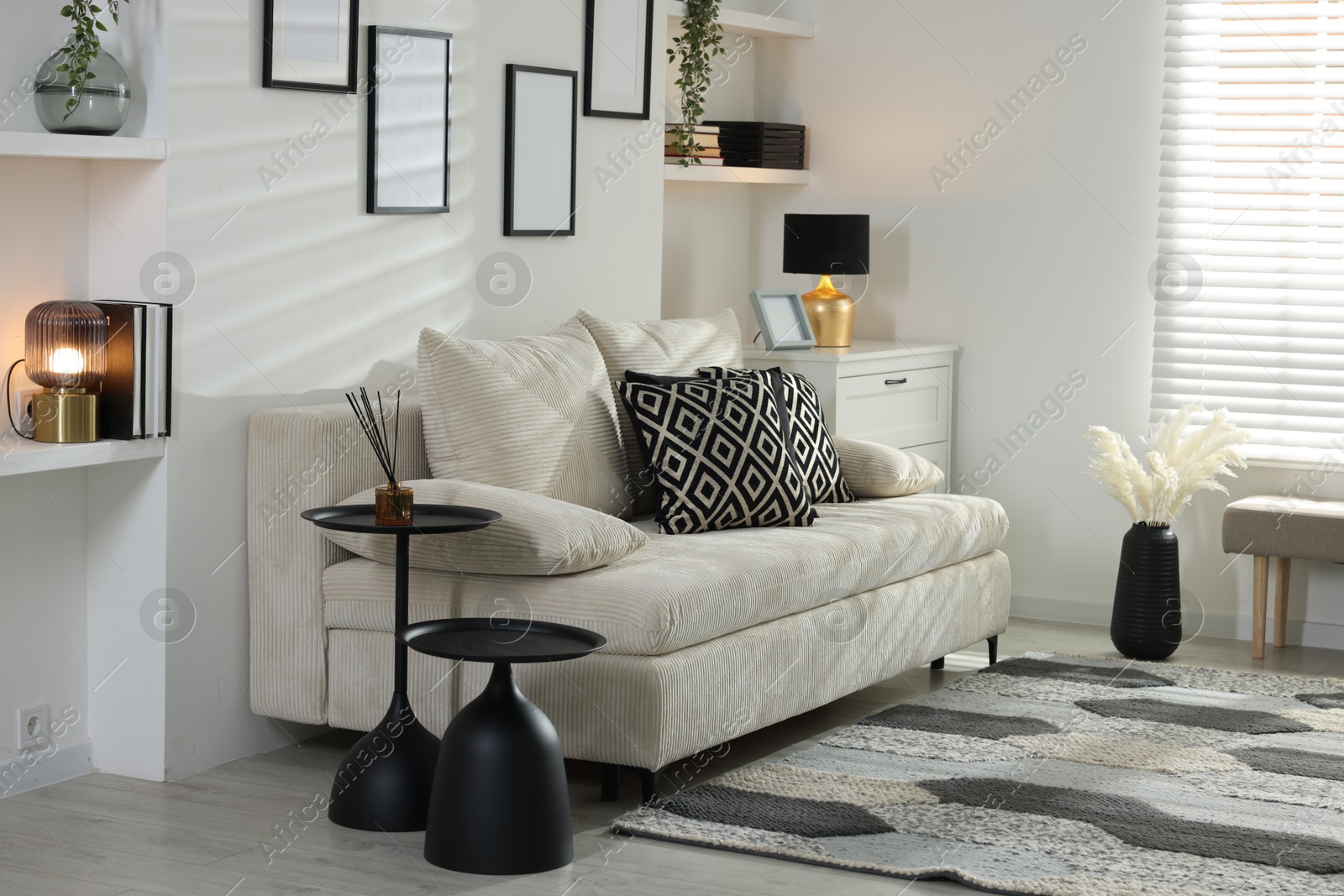 Comfortable sofa, dresser and different decor indoors. Interior design Photo of Comfortable sofa, dresser and different decor indoors. Interior design