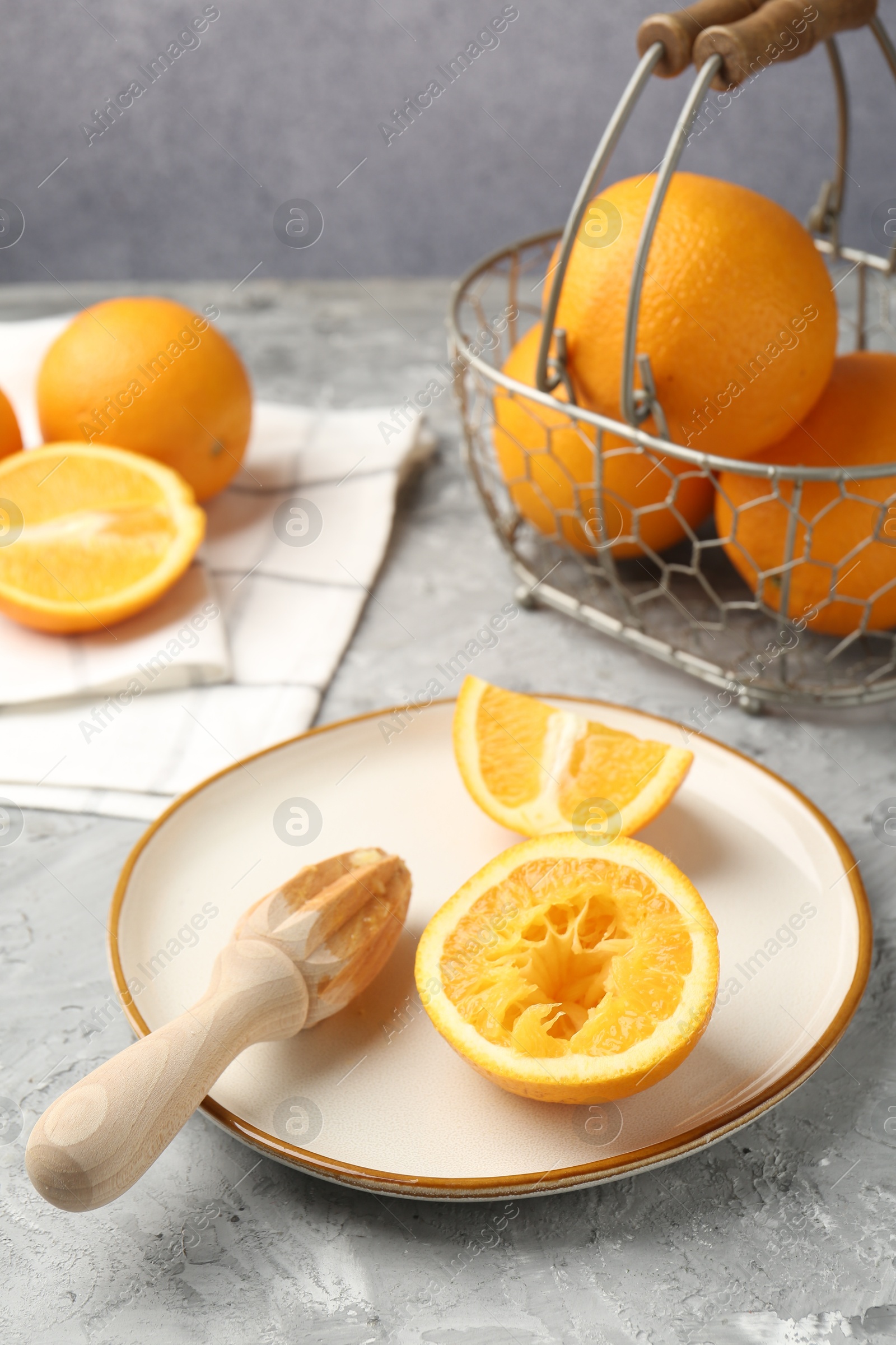 Wooden juicer and fresh oranges on grey table, closeup Photo of Wooden juicer and fresh oranges on grey table, closeup