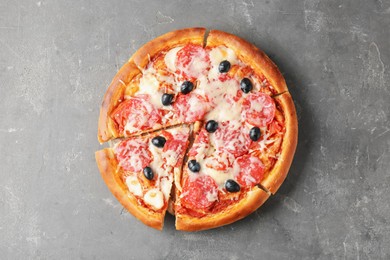 Photo of Tasty pizza with salami, cheese and olives on grey table, top view