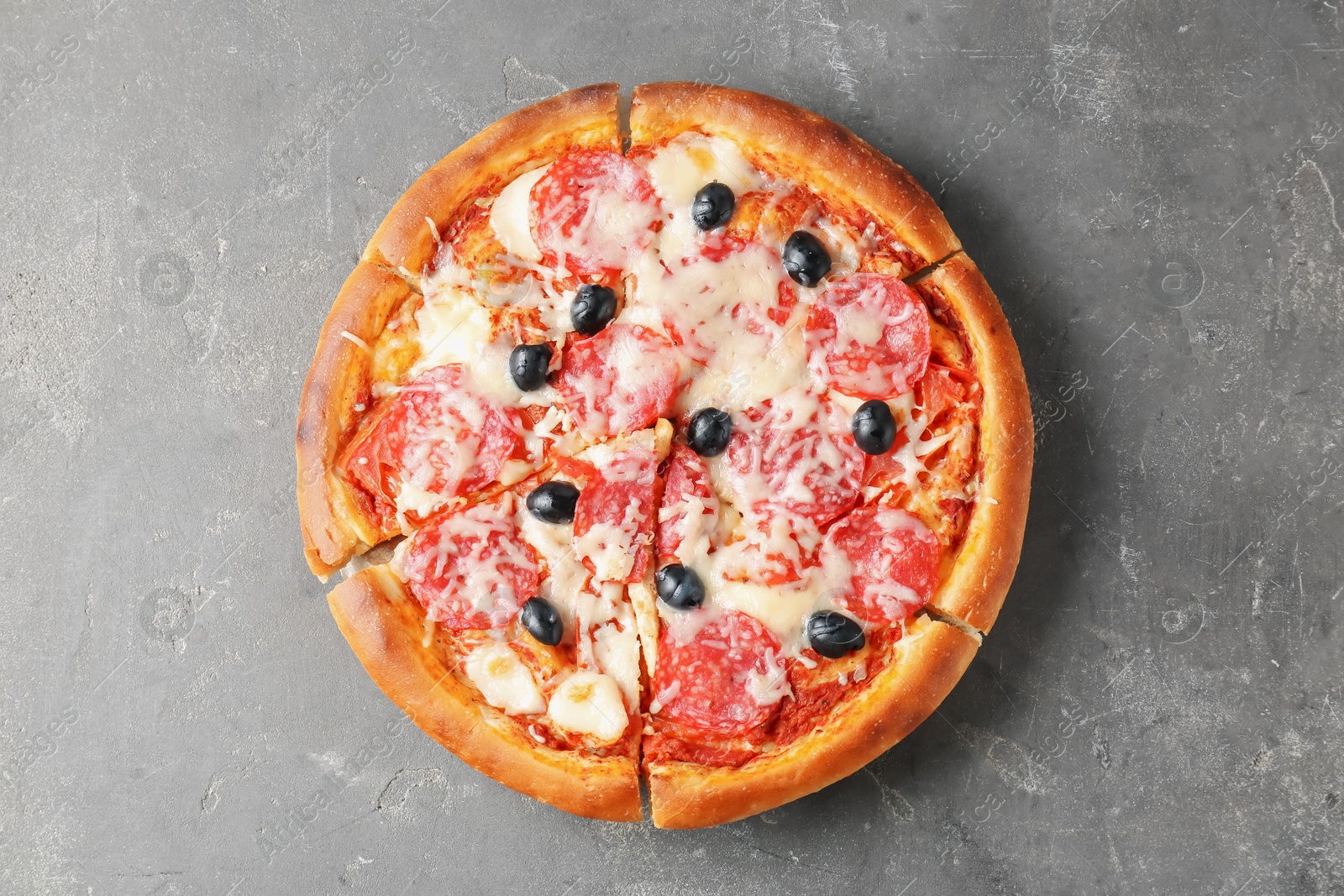 Tasty pizza with salami, cheese and olives on grey table, top view Photo of Tasty pizza with salami, cheese and olives on grey table, top view