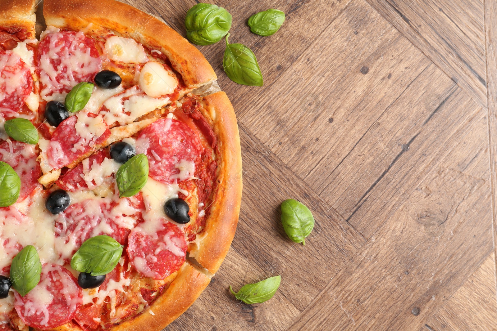 Tasty pizza with salami, cheese, basil and olives on wooden table, flat lay. Space for text Photo of Tasty pizza with salami, cheese, basil and olives on wooden table, flat lay. Space for text