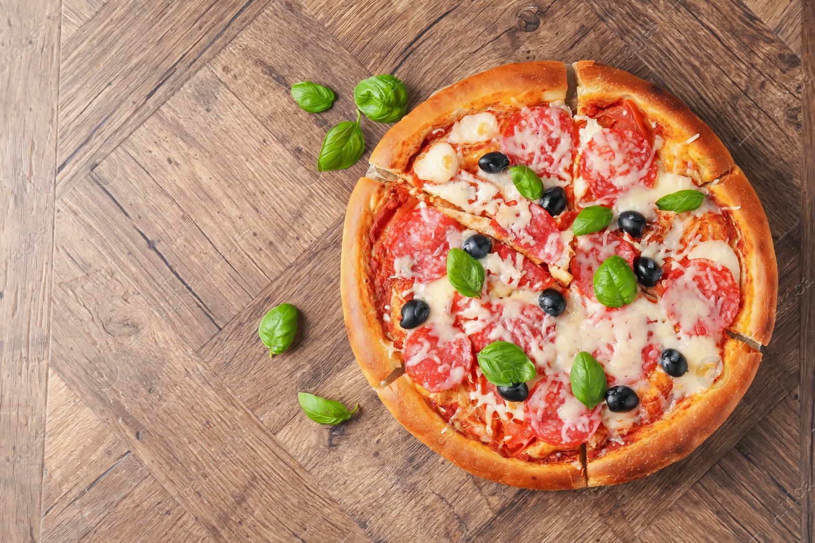 Tasty pizza with salami, cheese, basil and olives on wooden table, flat lay. Space for text Photo of Tasty pizza with salami, cheese, basil and olives on wooden table, flat lay. Space for text