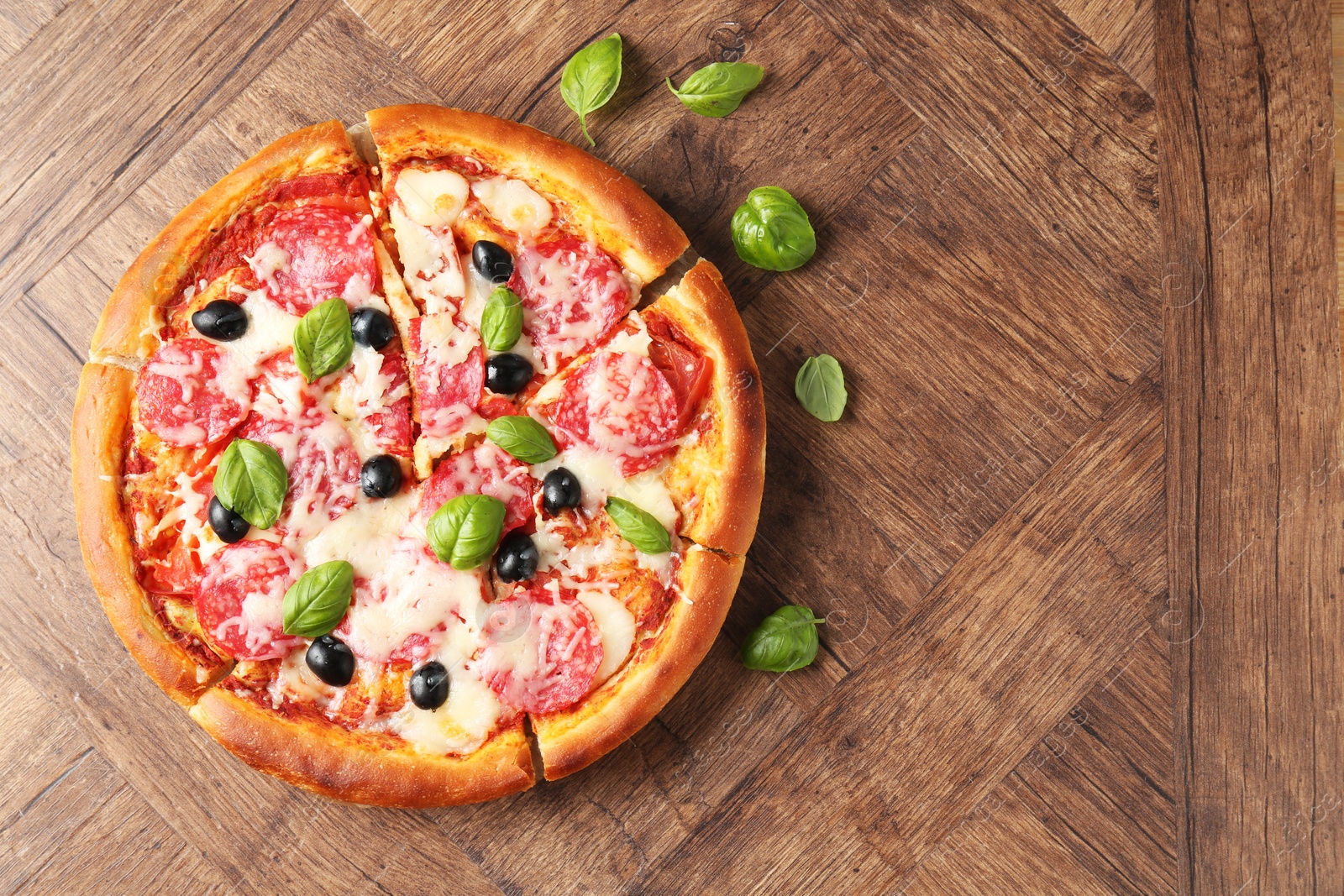 Tasty pizza with salami, cheese, basil and olives on wooden table, flat lay. Space for text Photo of Tasty pizza with salami, cheese, basil and olives on wooden table, flat lay. Space for text