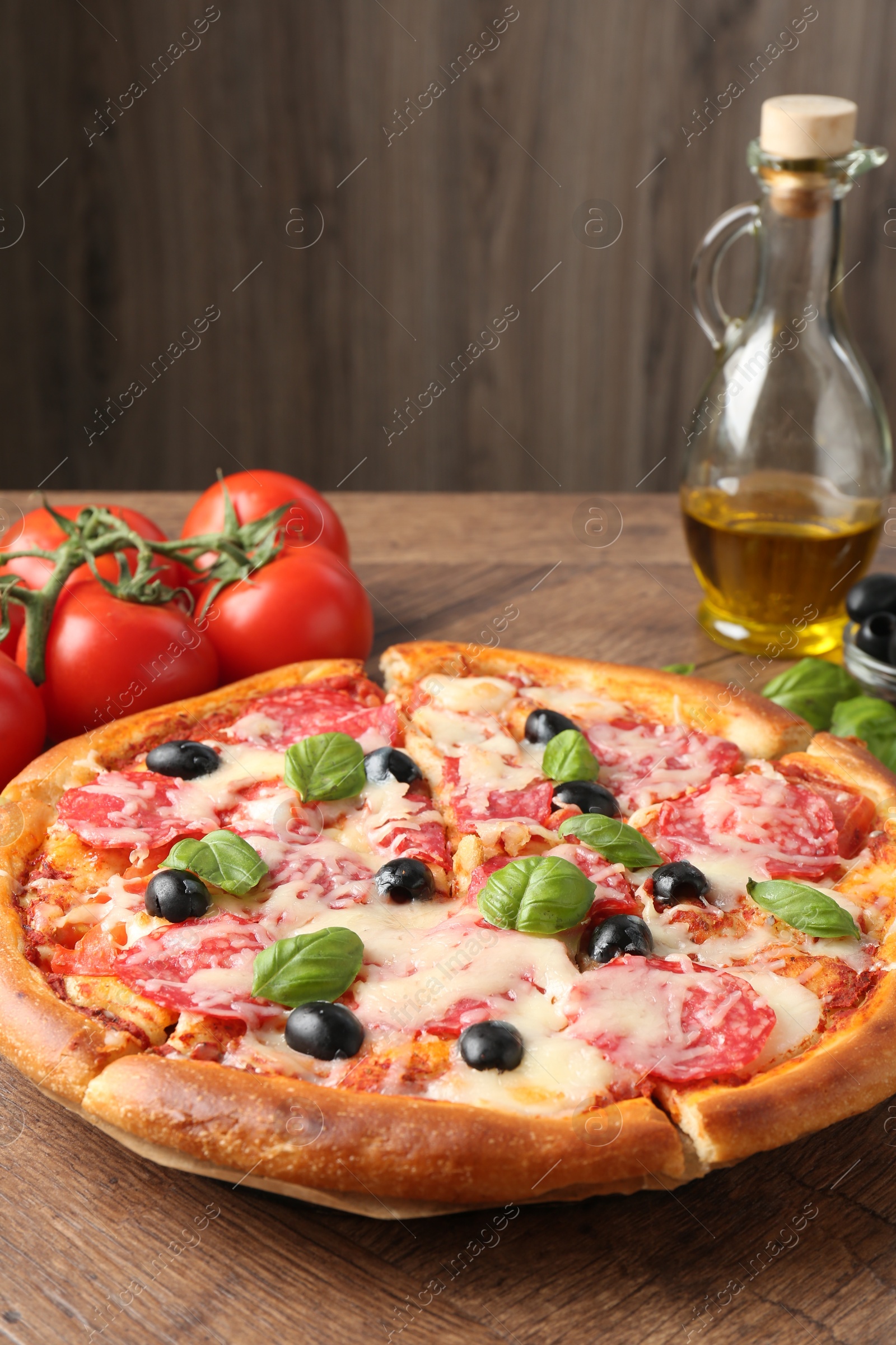 Tasty pizza and ingredients on wooden table, closeup Photo of Tasty pizza and ingredients on wooden table, closeup