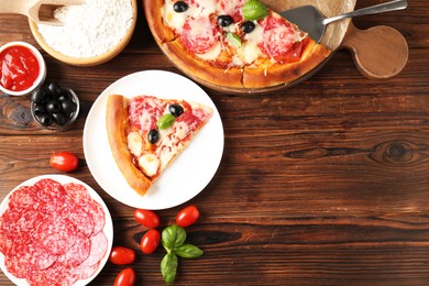 Photo of Tasty pizza and ingredients on wooden table, flat lay. Space for text