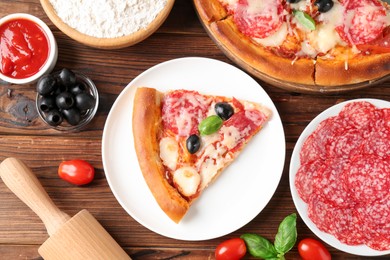 Photo of Tasty pizza and ingredients on wooden table, flat lay