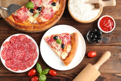 Photo of Tasty pizza and ingredients on wooden table, flat lay