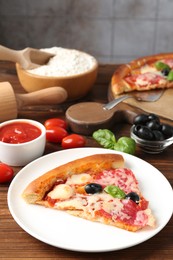 Photo of Tasty pizza and ingredients on wooden table, closeup