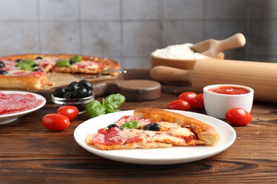 Photo of Tasty pizza and ingredients on wooden table, closeup