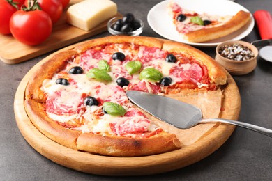 Photo of Tasty pizza and ingredients on grey table, closeup
