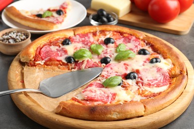 Photo of Tasty pizza and ingredients on grey table, closeup