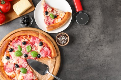 Photo of Tasty pizza and ingredients on grey table, flat lay. Space for text