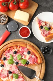 Photo of Tasty pizza and ingredients on grey table, flat lay