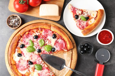 Photo of Tasty pizza and ingredients on grey table, flat lay