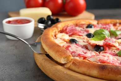Photo of Tasty pizza served on grey table, closeup