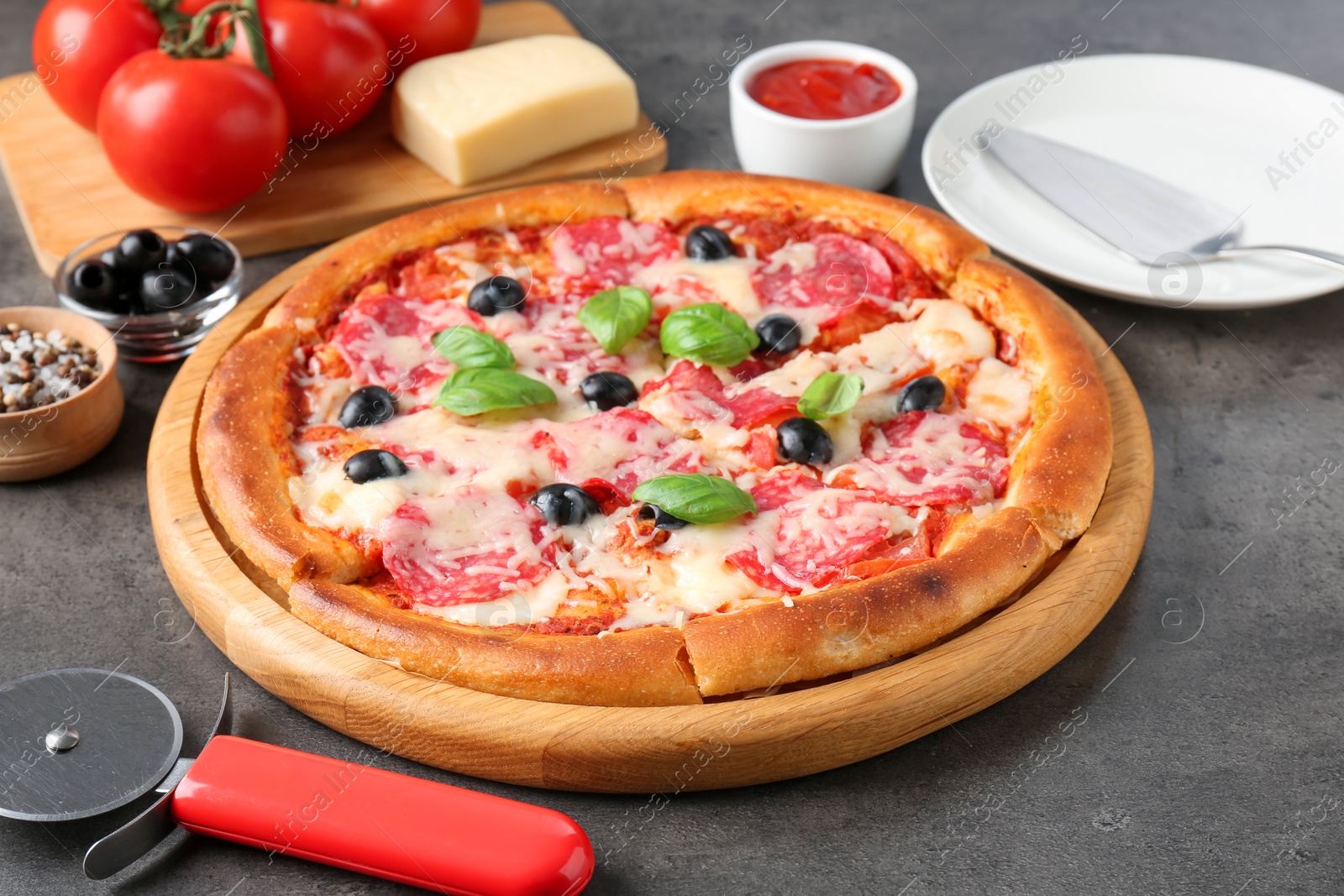 Tasty pizza and ingredients on grey table, closeup Photo of Tasty pizza and ingredients on grey table, closeup