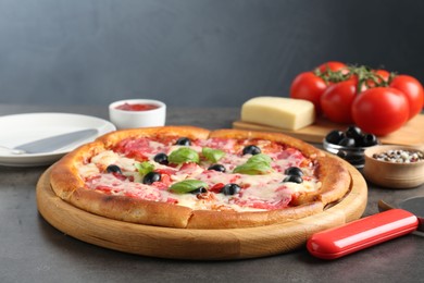 Photo of Tasty pizza and ingredients on grey table, closeup