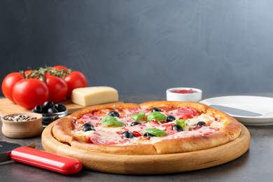 Photo of Tasty pizza and ingredients on grey table, closeup