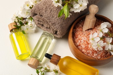 Photo of Spa composition with cosmetic products and beautiful flowers on white table, above view