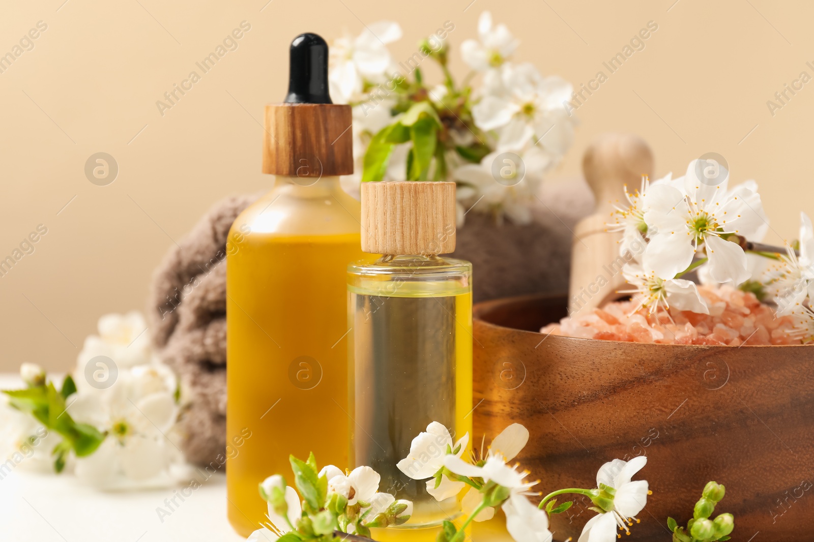 Spa composition with cosmetic products and beautiful flowers on beige table, closeup Photo of Spa composition with cosmetic products and beautiful flowers on beige table, closeup