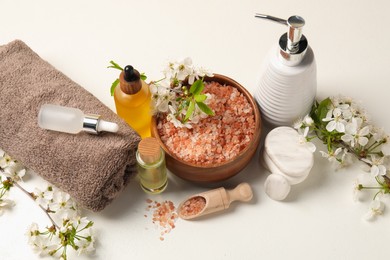 Photo of Spa composition with cosmetic products and beautiful flowers on white table, above view