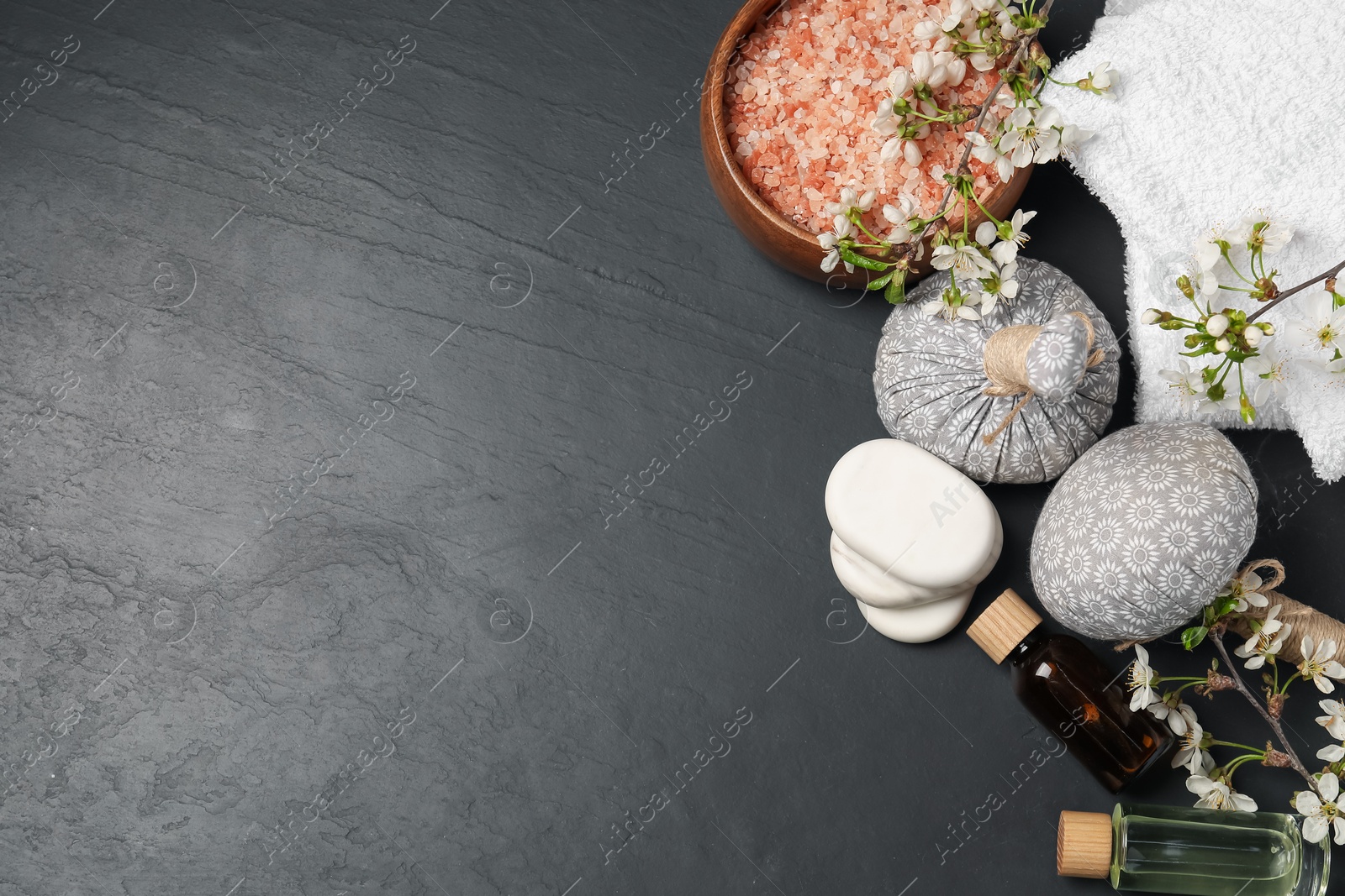 Spa composition with cosmetic products and beautiful flowers on black textured table, flat lay. Space for text Photo of Spa composition with cosmetic products and beautiful flowers on black textured table, flat lay. Space for text