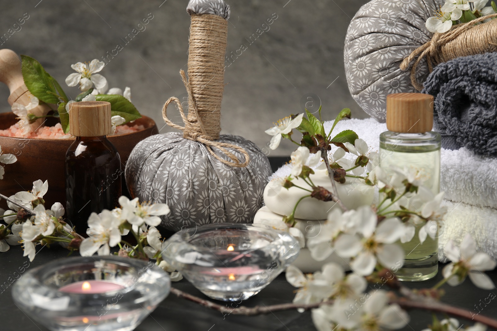 Spa composition with cosmetic products, burning candles and beautiful flowers on table, closeup Photo of Spa composition with cosmetic products, burning candles and beautiful flowers on table, closeup