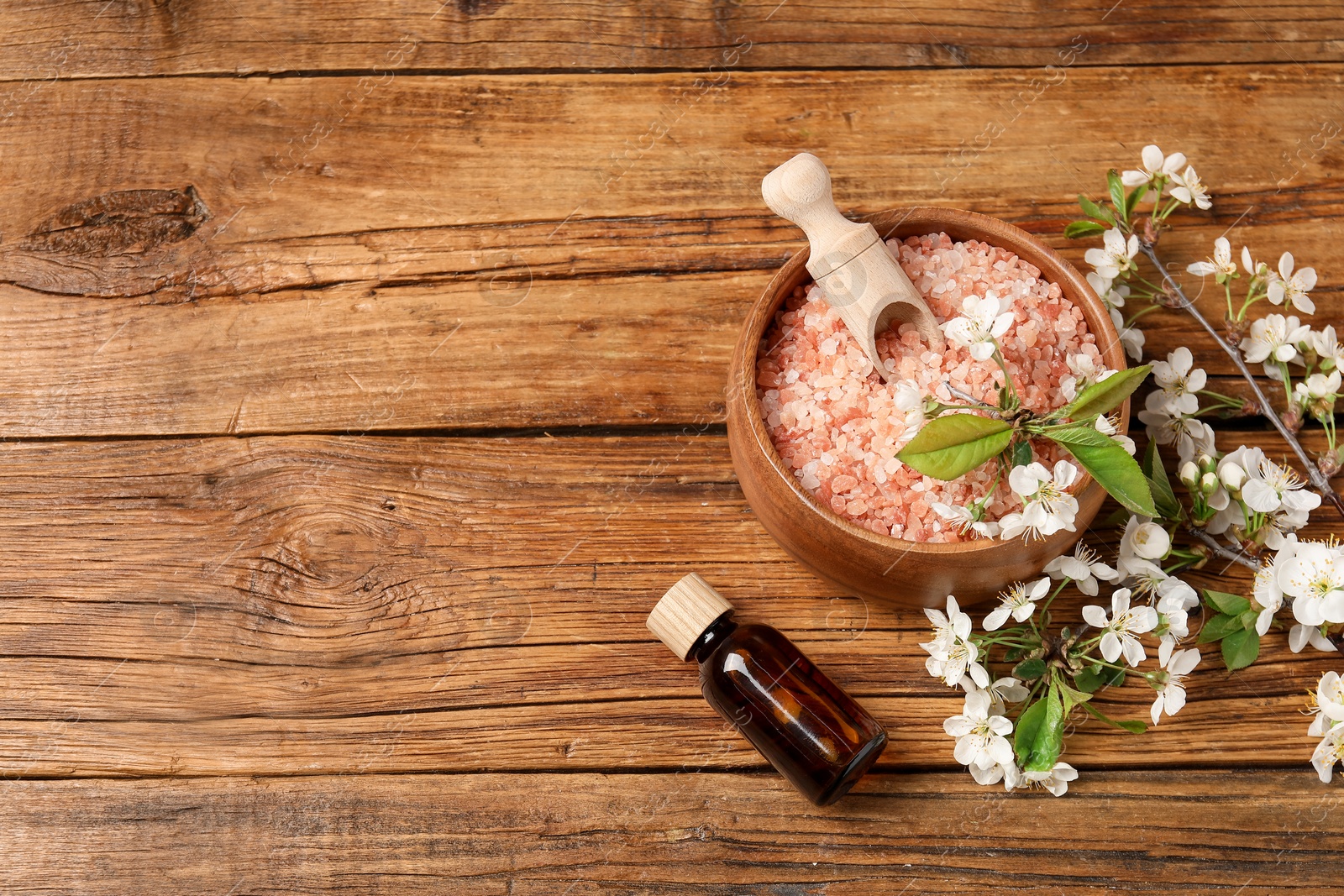 Spa composition with sea salt, cosmetic product and beautiful flowers on wooden table, flat lay. Space for text Photo of Spa composition with sea salt, cosmetic product and beautiful flowers on wooden table, flat lay. Space for text