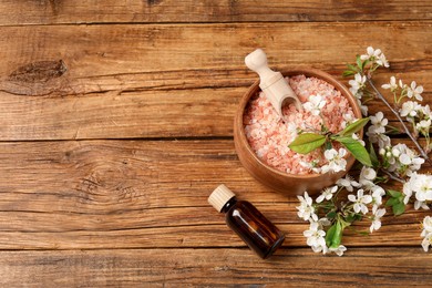 Photo of Spa composition with sea salt, cosmetic product and beautiful flowers on wooden table, flat lay. Space for text
