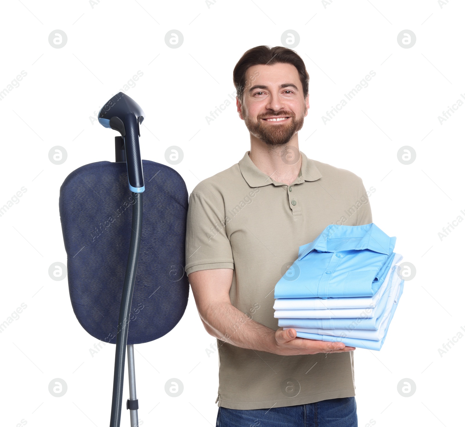 Man with stand steamer and stack of clothes on white background Photo of Man with stand steamer and stack of clothes on white background