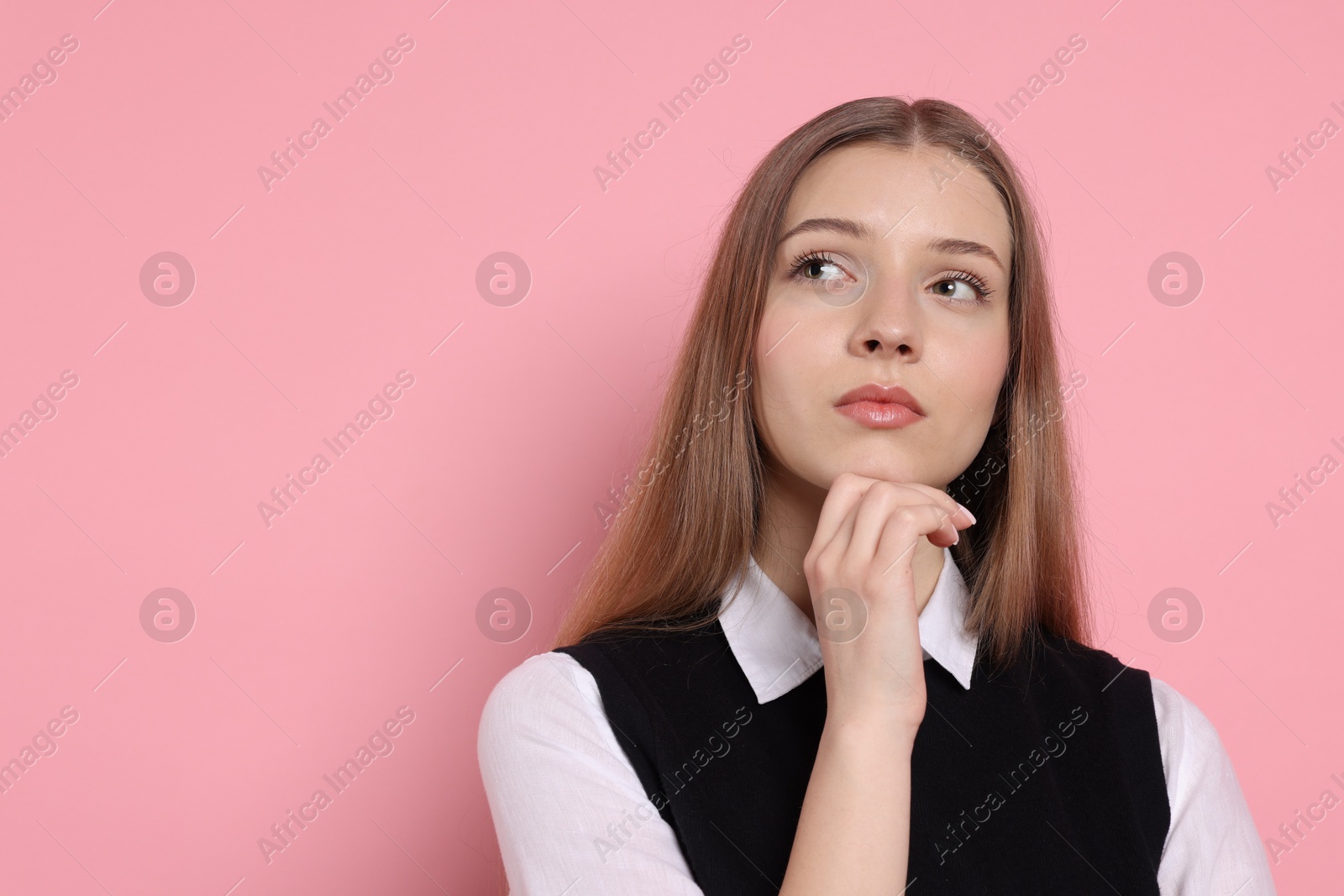 Pensive teenage girl on light pink background. Space for text Photo of Pensive teenage girl on light pink background. Space for text