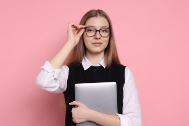 Photo of Beautiful teenage girl with laptop on pink background