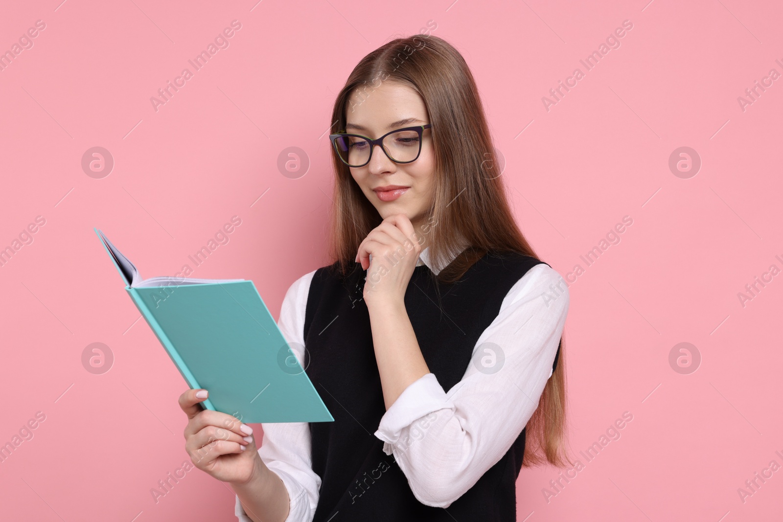 Photo of Teenage girl with book on light pink background
