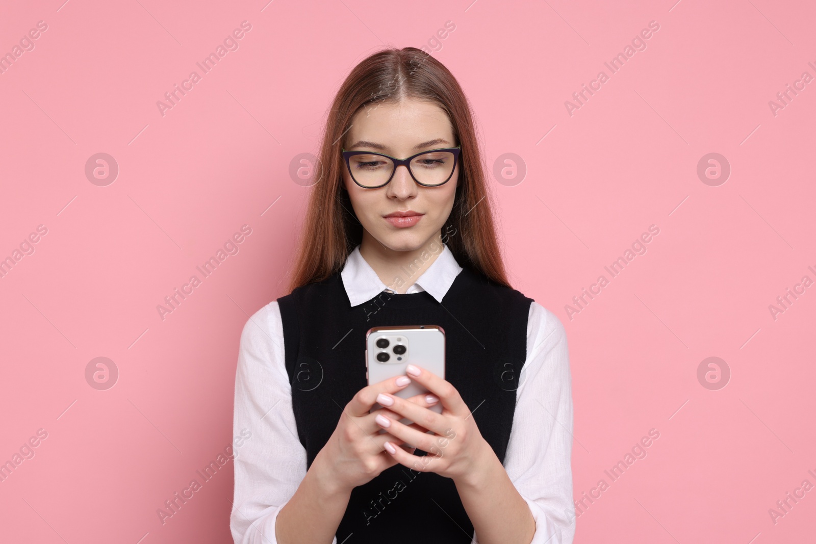 Photo of Teenage girl with smartphone on light pink background