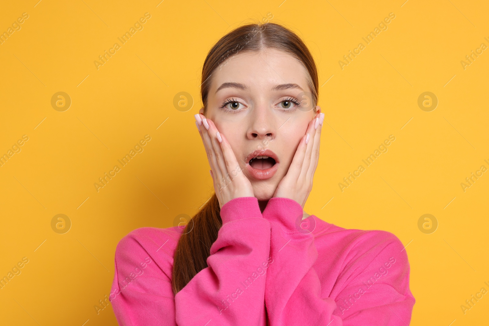 Photo of Portrait of emotional teenage girl on yellow background