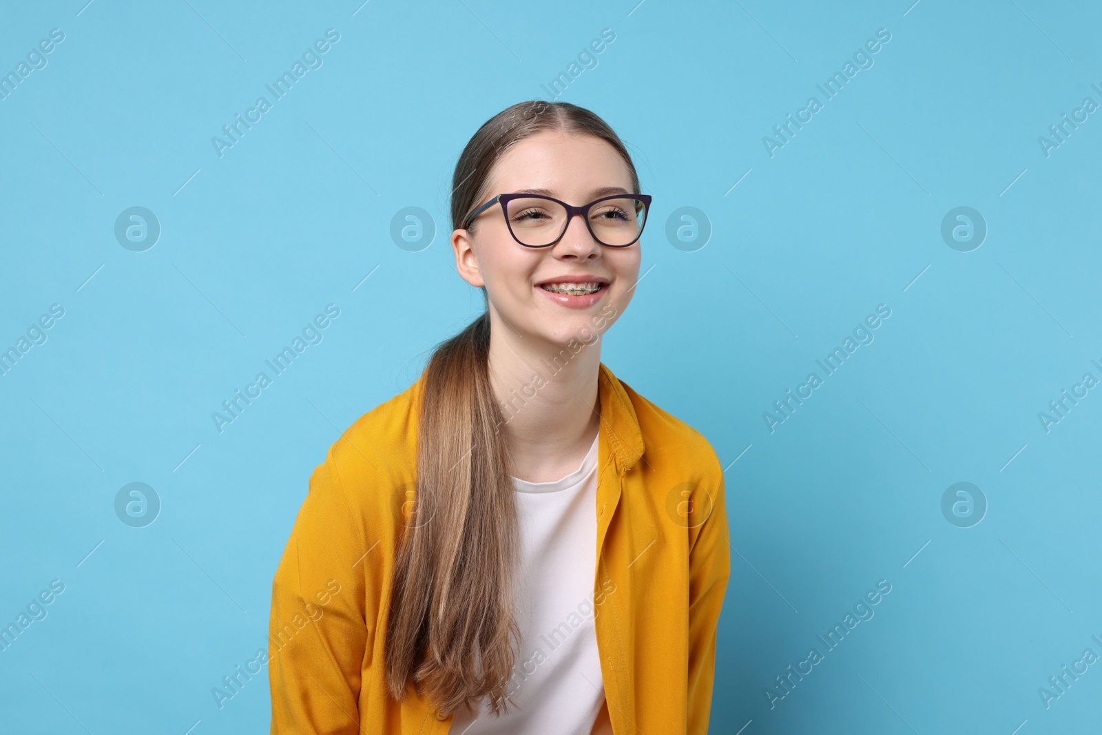 Portrait of teenage girl on light blue background Photo of Portrait of teenage girl on light blue background