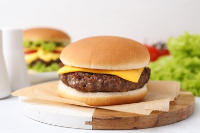 Photo of Cheeseburger with tasty patty on white table, closeup