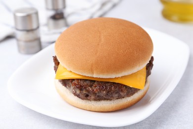 Photo of Cheeseburger with tasty patty on white table, closeup