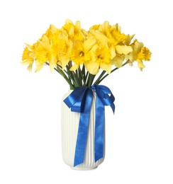 Photo of Yellow daffodils with ribbon in vase isolated on white
