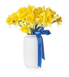 Photo of Yellow daffodils with ribbon in vase isolated on white