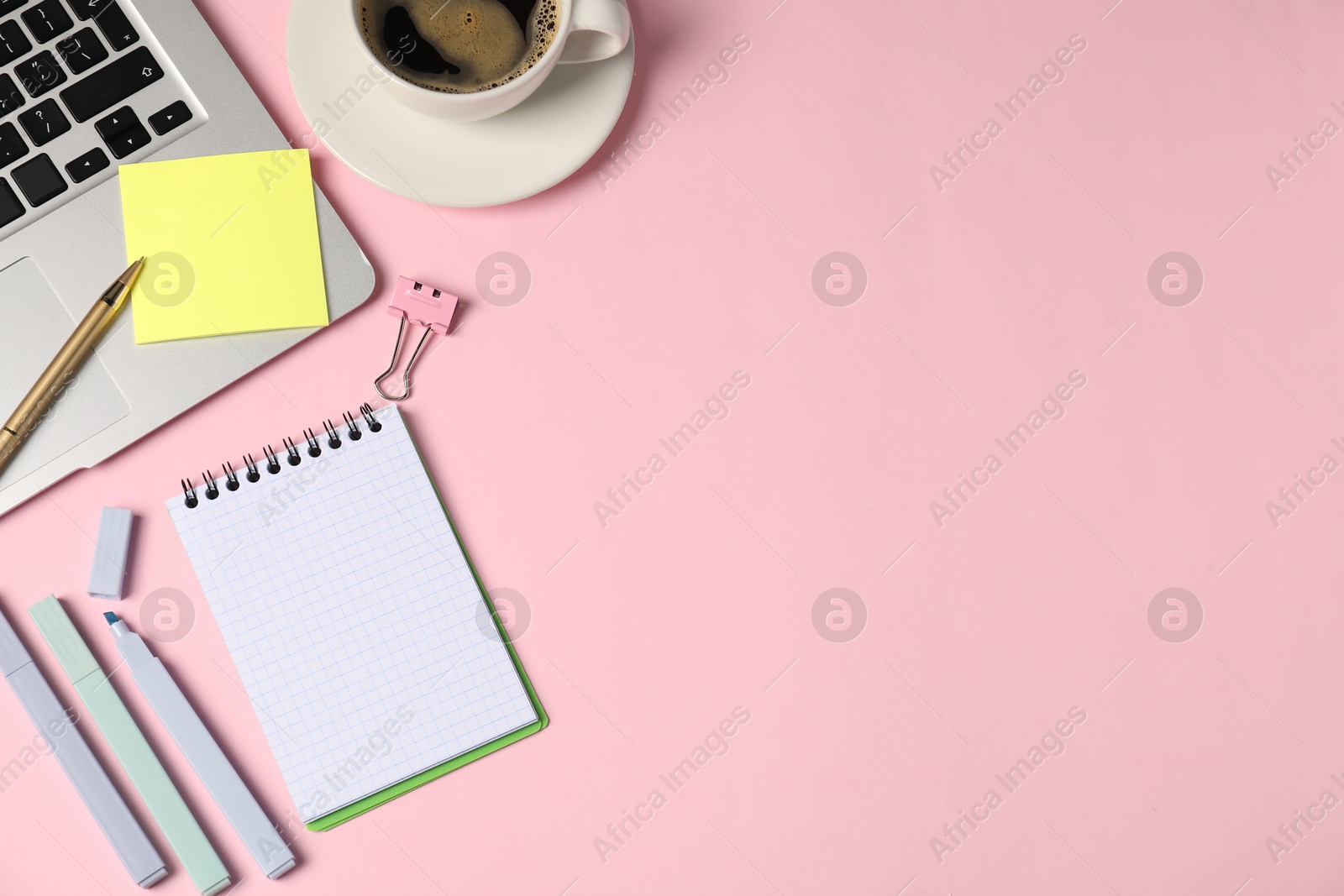 Notebook, sticky note, pen, markers, binder clip, coffee and laptop on pink background, flat lay. Space for text Photo of Notebook, sticky note, pen, markers, binder clip, coffee and laptop on pink background, flat lay. Space for text