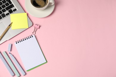 Photo of Notebook, sticky note, pen, markers, binder clip, coffee and laptop on pink background, flat lay. Space for text