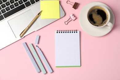 Photo of Notebook, sticky note, pen, markers, binder clips, coffee and laptop on pink background, flat lay