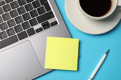 Photo of Sticky note, pen, coffee and laptop on light blue background, flat lay
