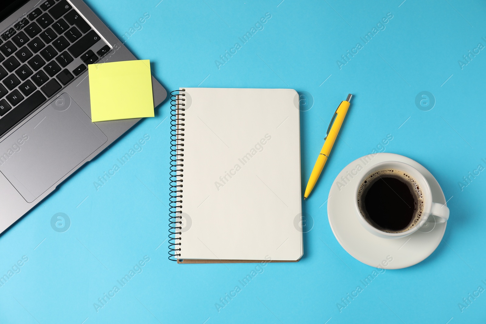 Notebook, sticky note, pen, coffee and laptop on light blue background, flat lay Photo of Notebook, sticky note, pen, coffee and laptop on light blue background, flat lay