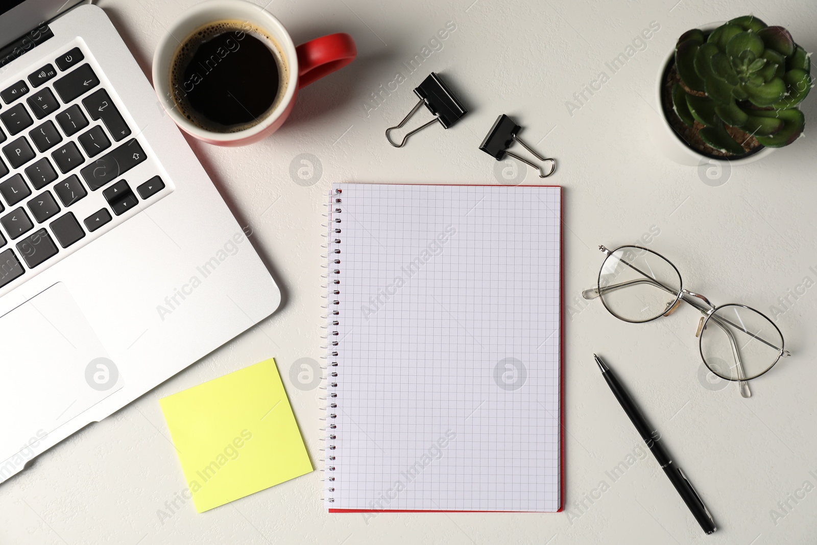 Notebook, sticky note, pen, floral decor, glasses, coffee and laptop on white table, flat lay Photo of Notebook, sticky note, pen, floral decor, glasses, coffee and laptop on white table, flat lay